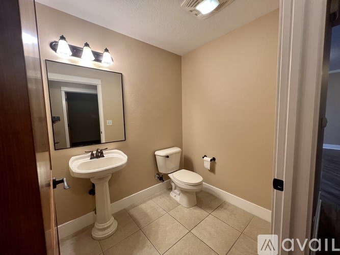 A bathroom with a sink, toilet and mirror.