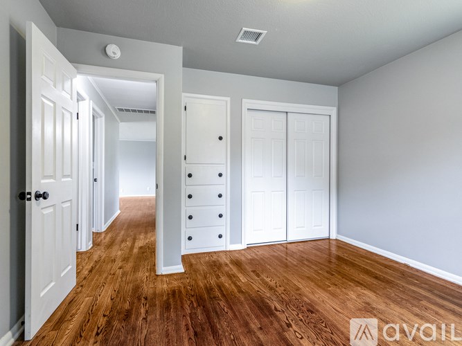 A room with white doors and wooden floors.