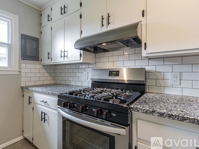 A modern kitchen with a stove top oven and cabinets.