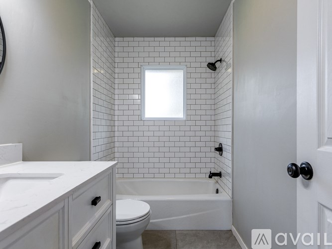 A white bathroom with a toilet, sink, and tub.