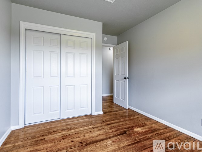 A room with white doors and wooden floors.