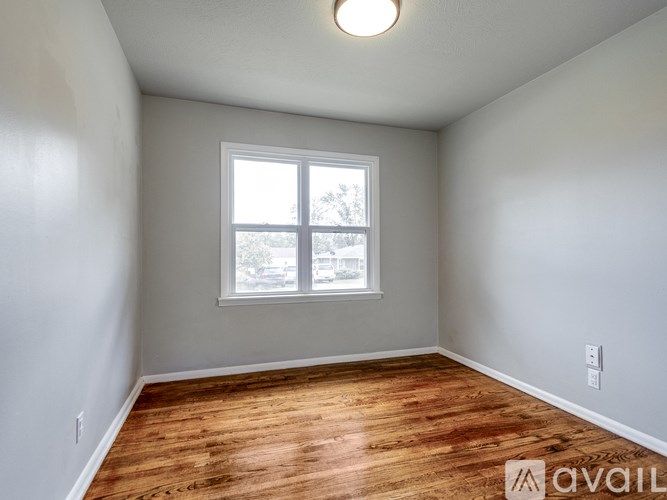 A room with wooden flooring and a window.
