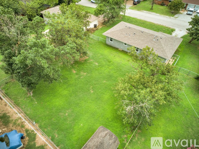 A house with a large yard and a tree in the foreground.