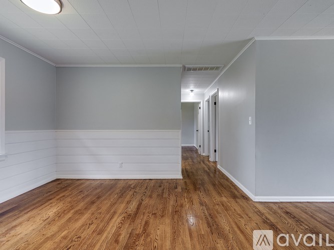 A room with wooden flooring and white walls.