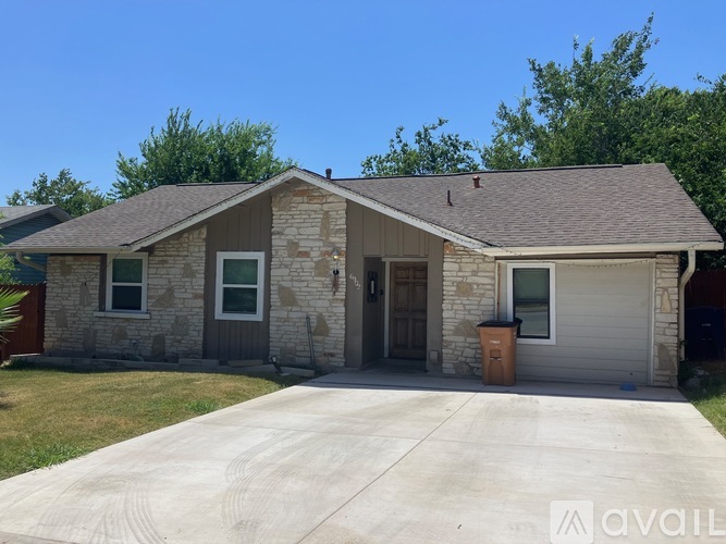 A house with a garage and a driveway in front.