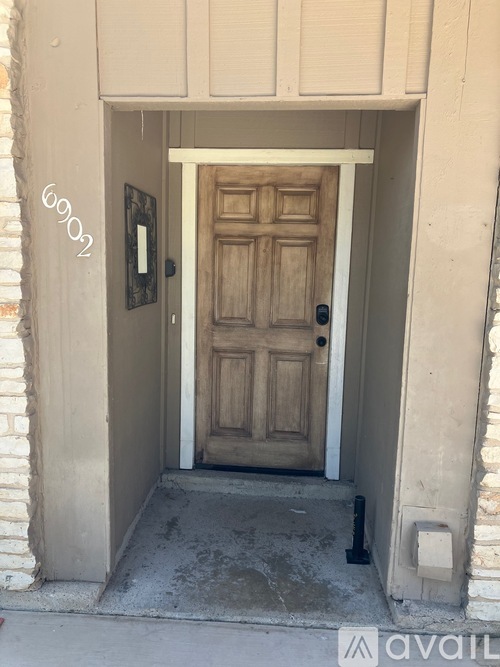 A wooden door is in a white doorway.