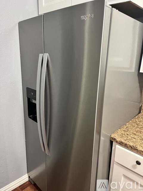 A Whirlpool brand refrigerator is in a kitchen.