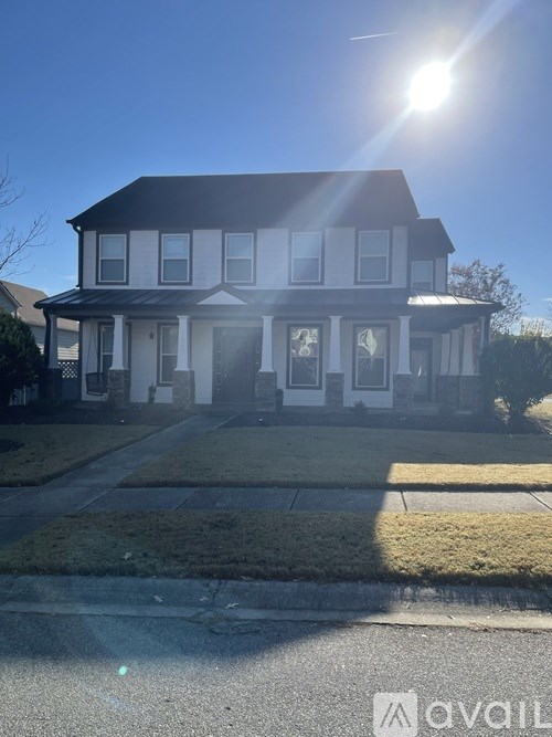 A house with a white facade and a black roof is shown in the image.