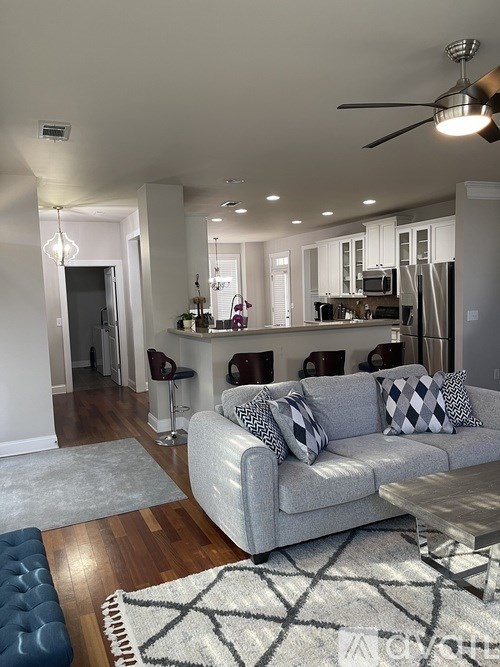 A modern living room with a grey couch and a patterned rug.