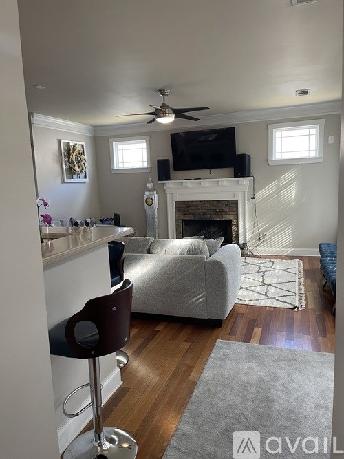 A living room with a grey couch and a fireplace.