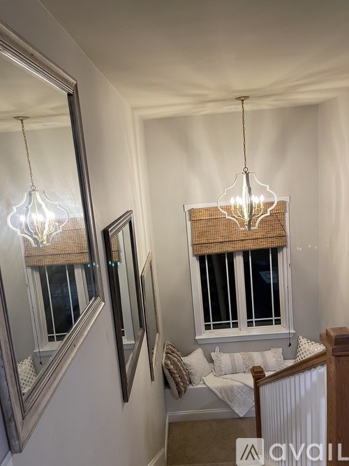 A bedroom with a large mirror and a chandelier hanging from the ceiling.