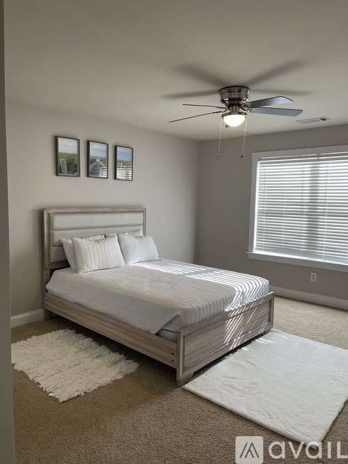 A bedroom with a large bed and a ceiling fan.