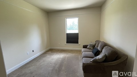 A living room with a couch and a window.