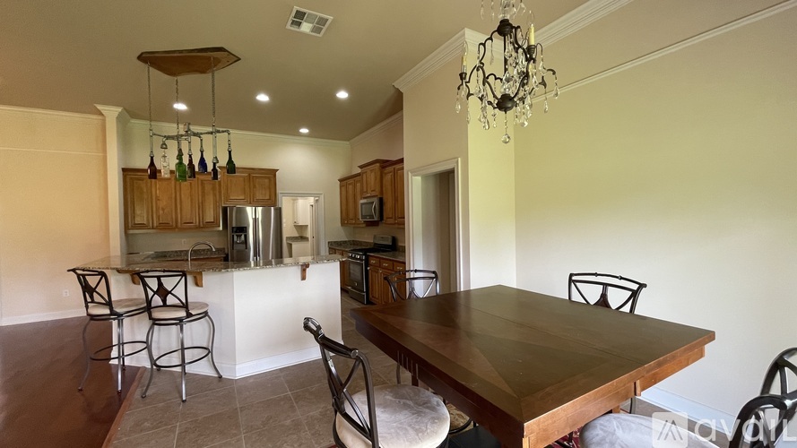 A kitchen with a wooden table and chairs.