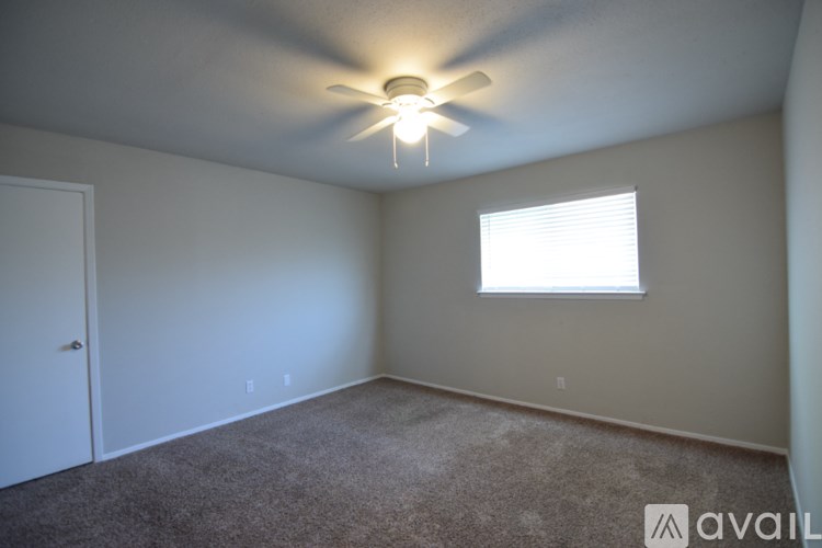 A room with a ceiling fan and a window.