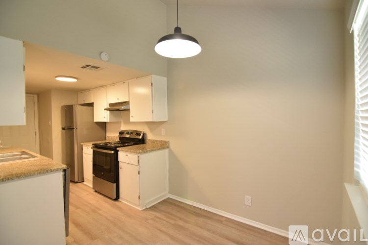 A kitchen with a stove top oven and cabinets.
