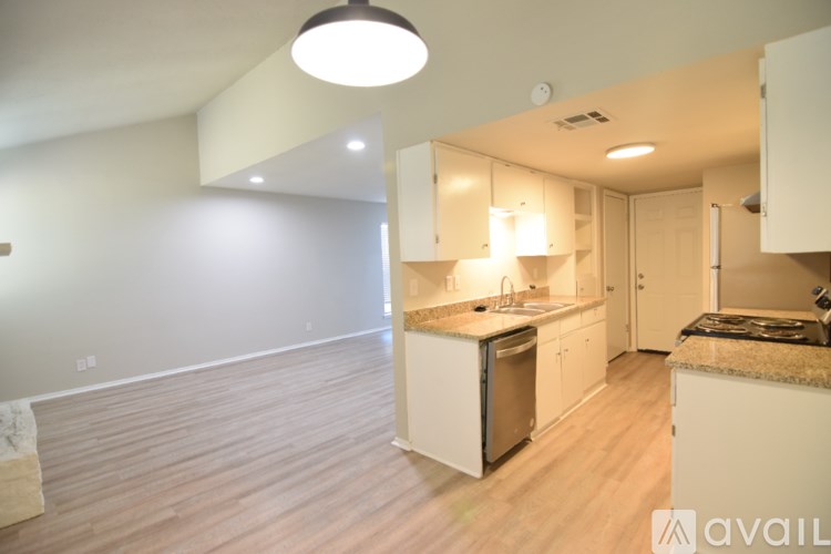 A kitchen with white cabinets and a wooden floor.