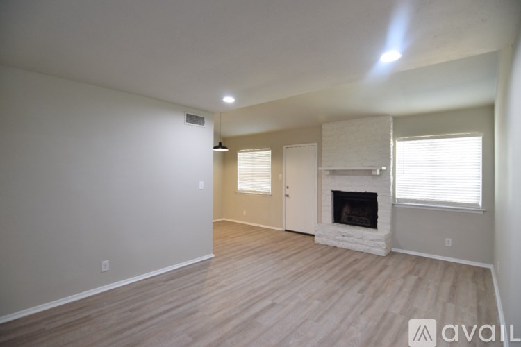 A living room with a fireplace and wooden floors.