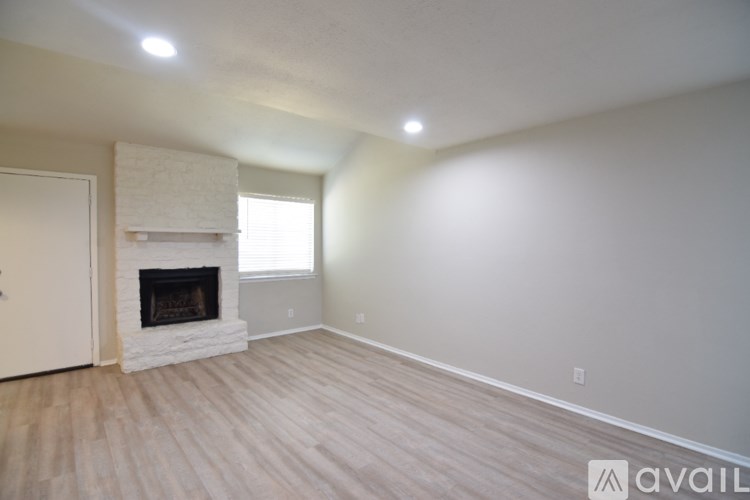 A room with a fireplace and wood flooring.