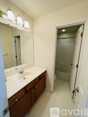 A bathroom with a sink, mirror, and shower.