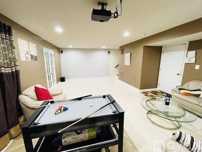 A pool table is in the middle of a living room.