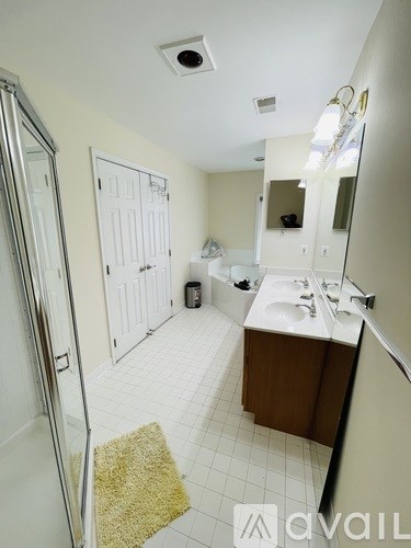 A bathroom with a sink, mirror, and shower.