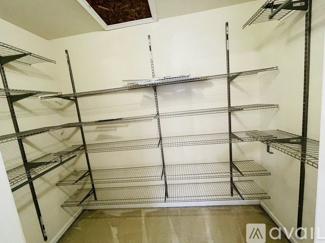 A white wall with metal shelving on it.