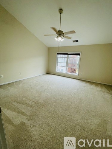 A room with a ceiling fan and a window.