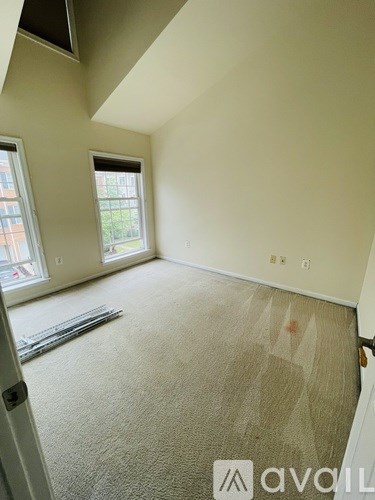 A room with a carpeted floor and a window.