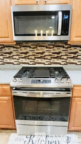 A stainless steel oven with a digital display is in a kitchen.
