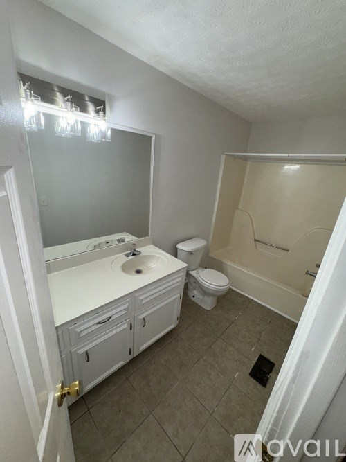 A bathroom with a sink, toilet, and bathtub.