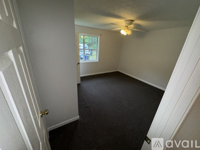 A room with a ceiling fan and a window.