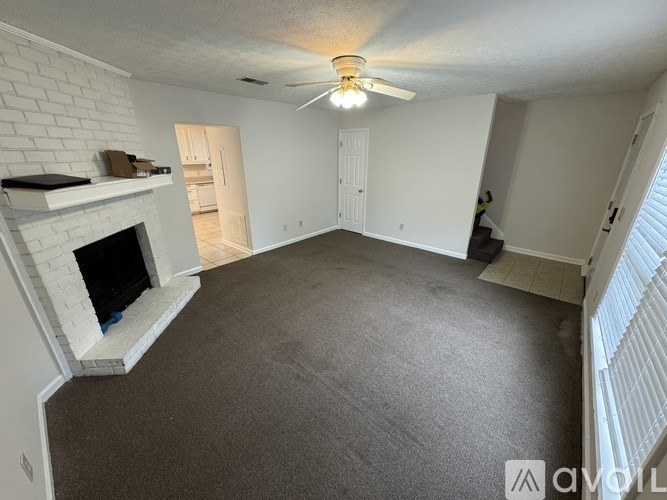 A living room with a fireplace and a ceiling fan.