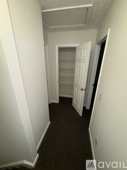 A hallway with a door on the right and a wall on the left.