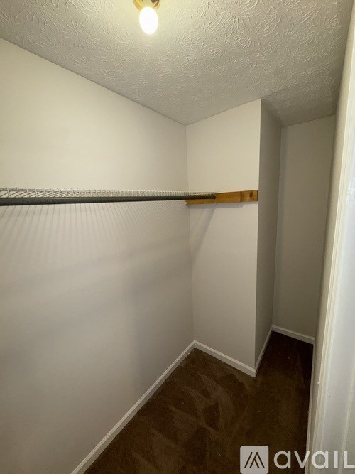 A small, empty room with a shelf and a light on.