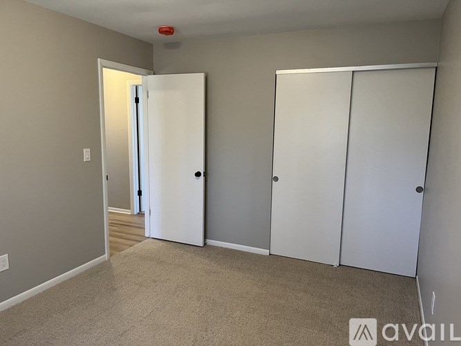 A room with two white doors and a carpeted floor.