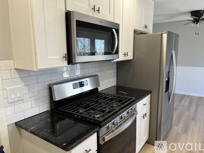 A kitchen with white cabinets and a black stove top oven.