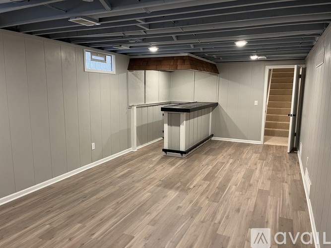 A room with wooden flooring and a white wall.