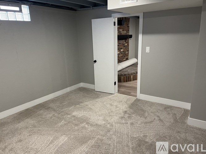 A room with a carpeted floor and a white door leading to a balcony.