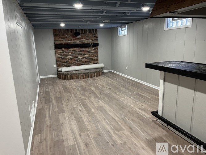 A room with wooden flooring and a brick wall.
