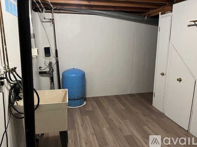 A room with a blue barrel and a white cabinet.