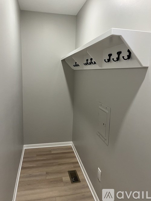 A hallway with a light switch and a wall hook.