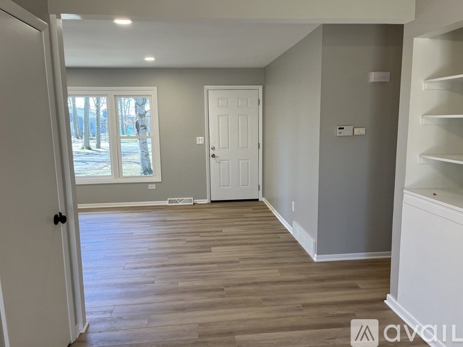 A room with wooden flooring and white walls.