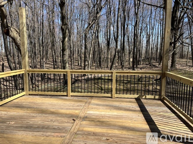 A wooden deck with a railing overlooking a forest.