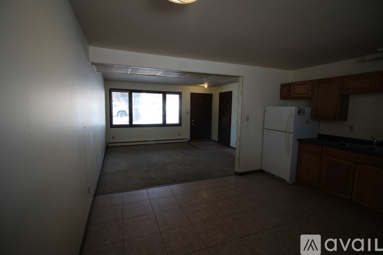 A kitchen area with a refrigerator, cabinets, and a counter.
