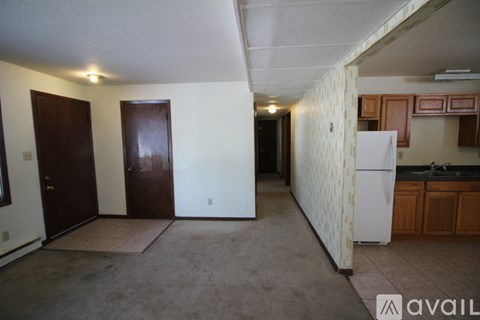 A kitchen area with a white refrigerator and wooden cabinets.