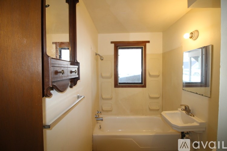 A bathroom with a bathtub, sink, and mirror.