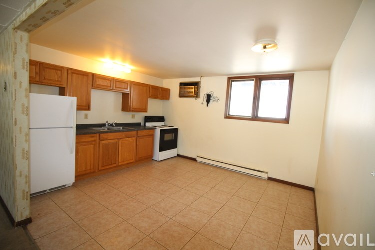 A kitchen with wooden cabinets and a white fridge.
