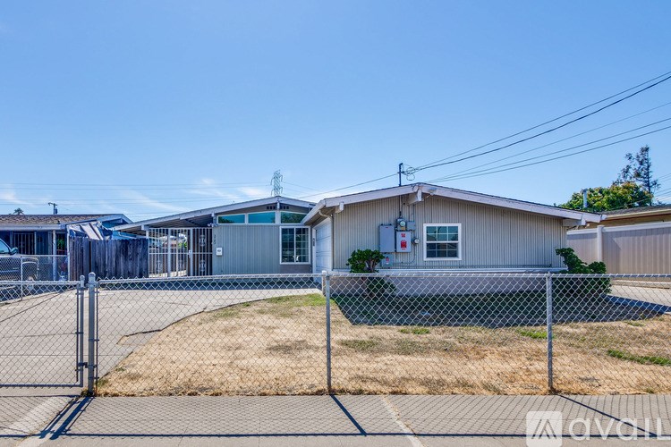 A house with a fence and a pool in the backyard.