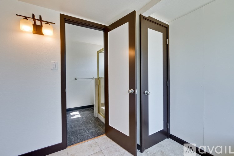 A bathroom with a glass door and a mirror.